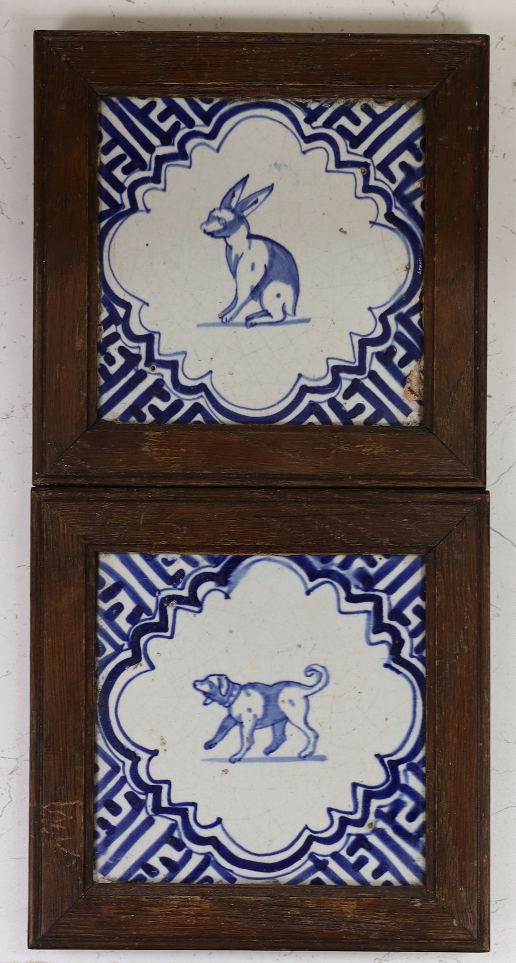 Two Delft blue and white tiles depicting a dog and a rabbit, c.1630, both individually framed, some damage